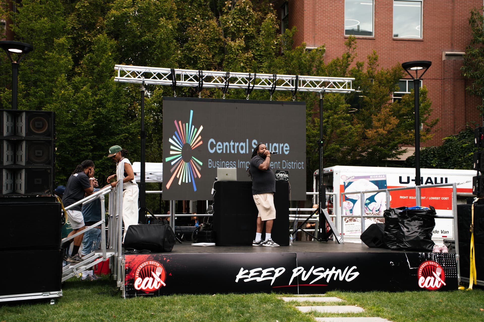 Host on stage at the Everybody Gotta Eat community event in Central Square, Cambridge