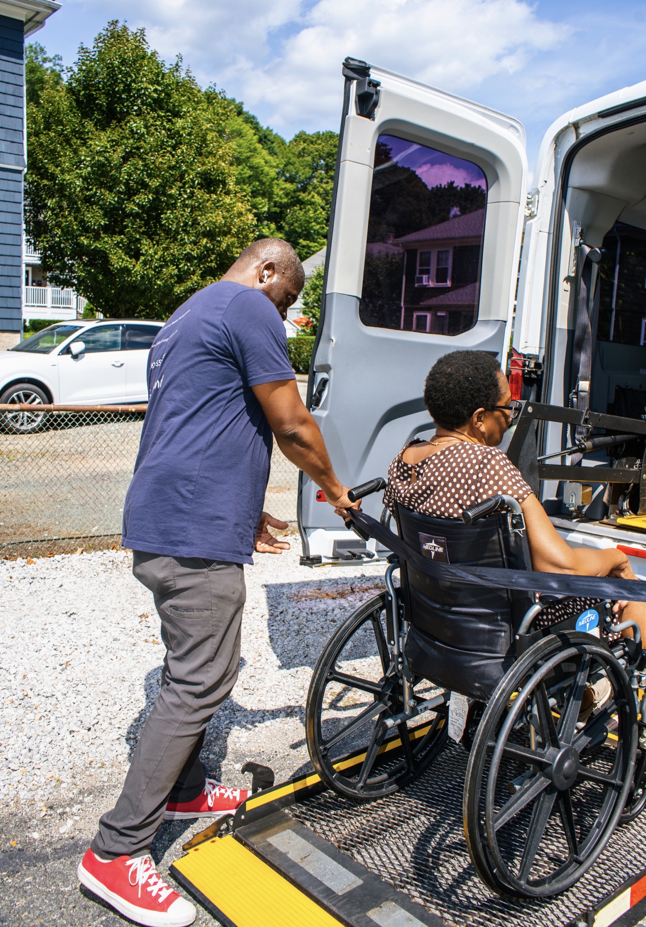 FedNor driver steadying a wheelchair rider at the van lift