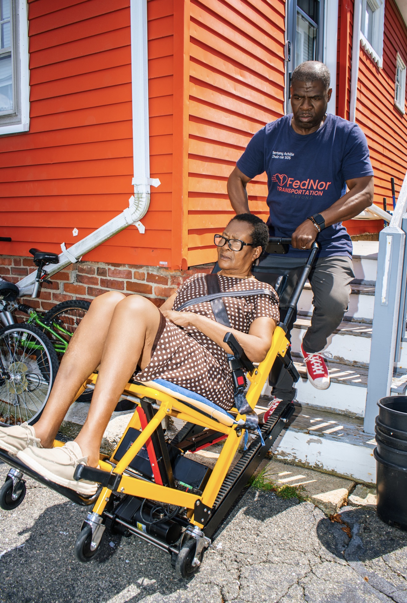 FedNor driver easing a stair chair off the last step of a home entrance