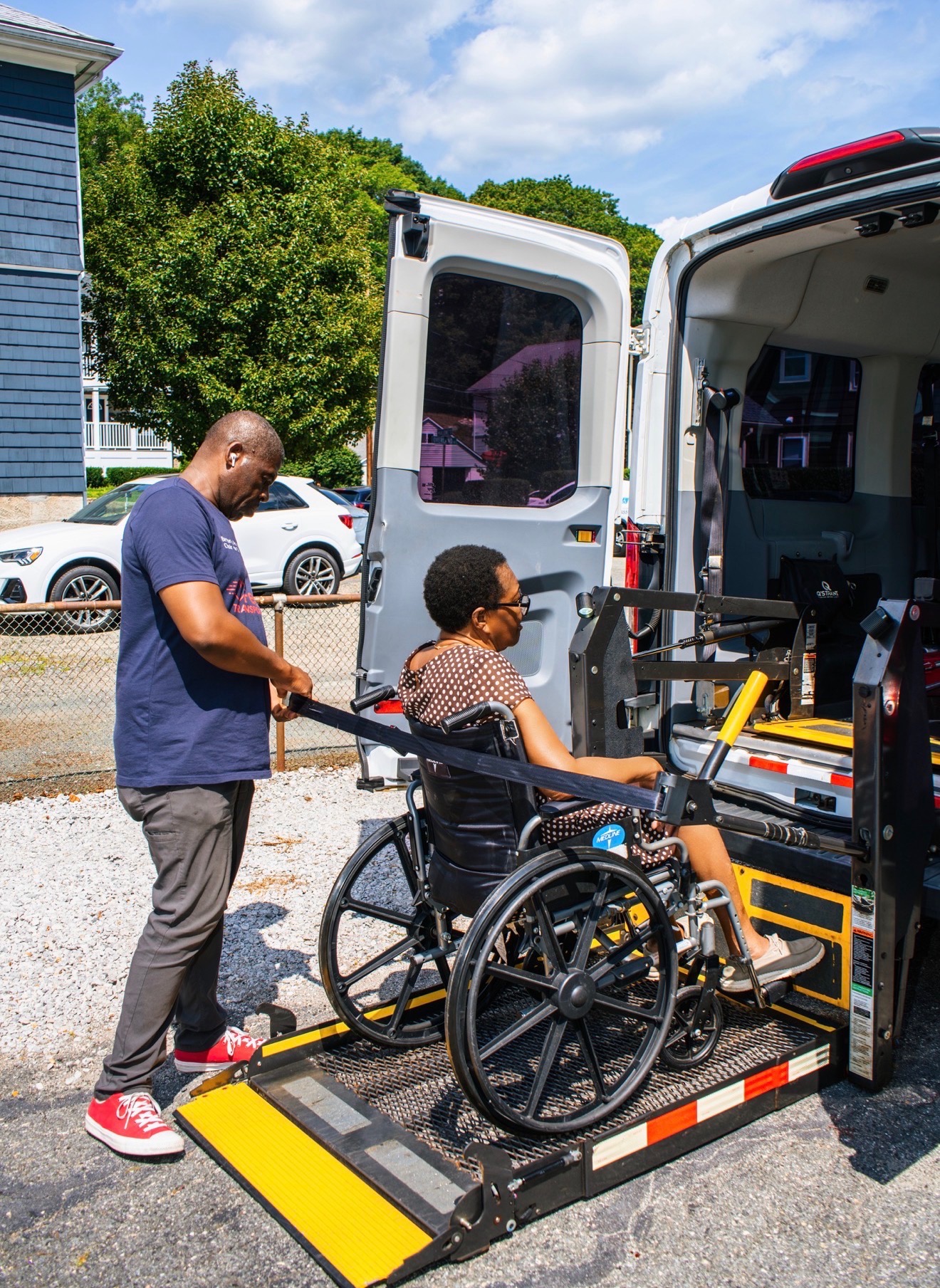 FedNor driver assisting a patient in a wheelchair onto a vehicle lift in Boston