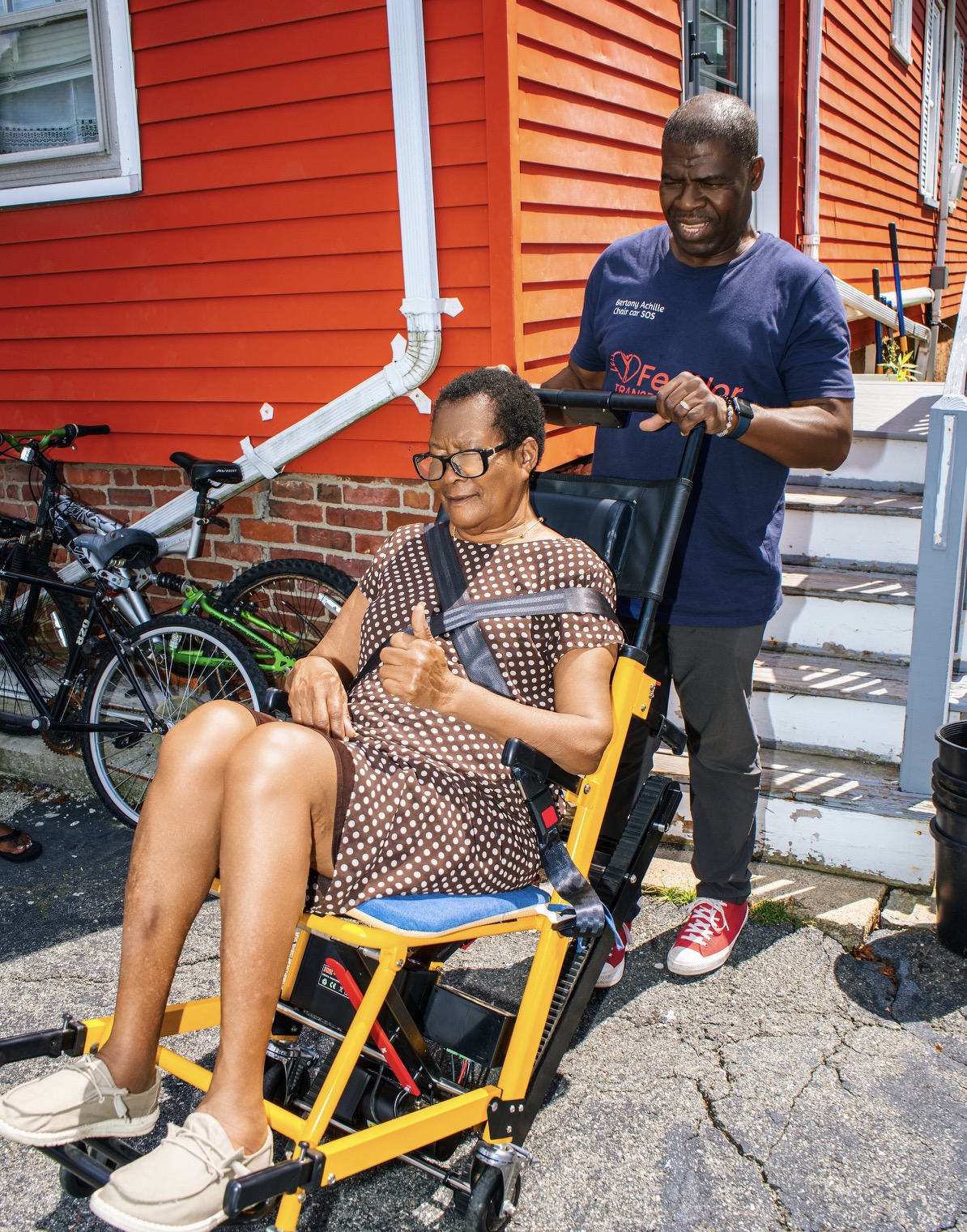 FedNor driver assisting a passenger seated in a powered stair chair