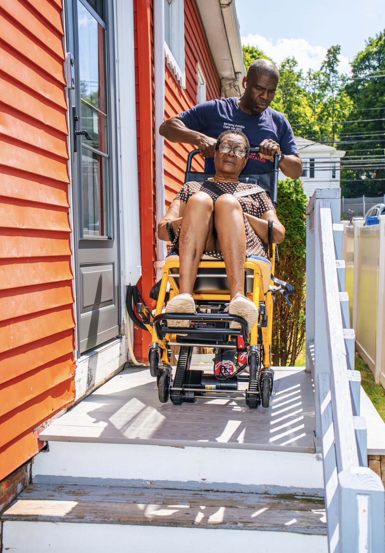 FedNor driver guiding a stair chair down a home walkway