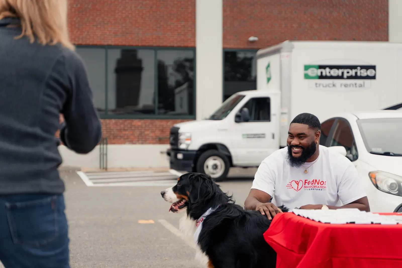 FedNor team member greeting community members with a therapy dog at outreach event