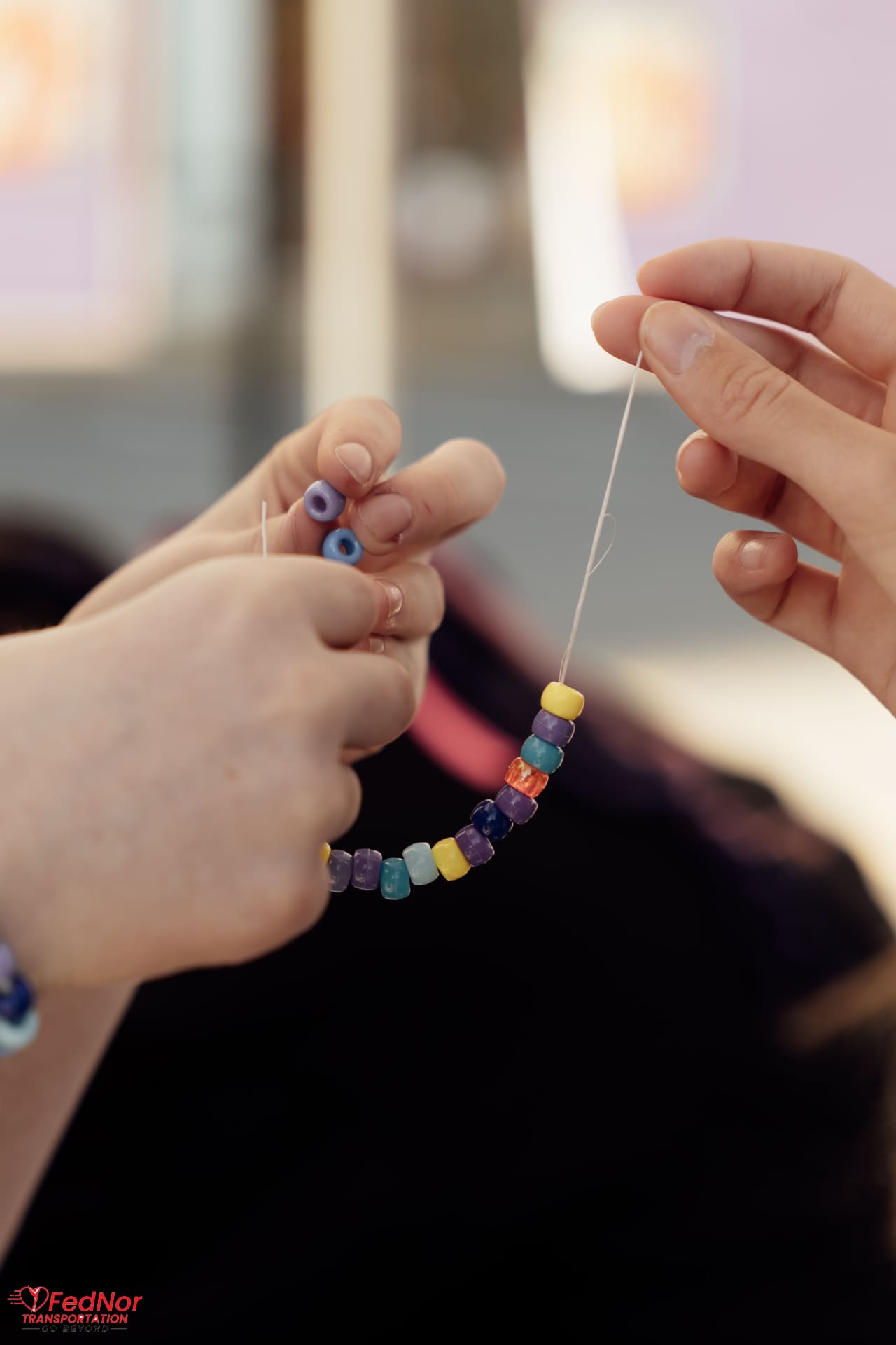 Close-up of colorful beaded bracelet being strung together